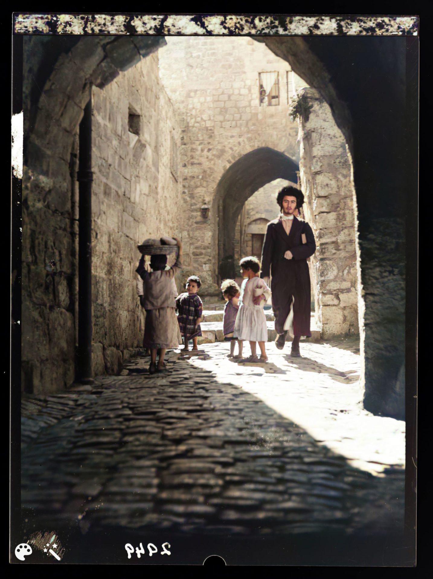 צעיר יהודי חולף על פני חבורת ילדים בסמטאות העיר העתיקה, אמצע שנות ה-20'. מספר תמונה: LC-DIG-matpc-15161